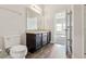 Bright bathroom featuring dark wood cabinets, wood look flooring, and brushed nickel fixtures at 3093 Neverland Dr, New Smyrna Beach, FL 32168