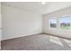 Bright bedroom featuring neutral walls and carpet, with views from two large windows at 3093 Neverland Dr, New Smyrna Beach, FL 32168