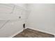 Efficient laundry room featuring wood-look flooring, wire shelving, and utility connections at 3093 Neverland Dr, New Smyrna Beach, FL 32168