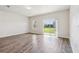 A bright open-plan living room with wood-look flooring and a sliding glass door at 3093 Neverland Dr, New Smyrna Beach, FL 32168