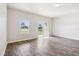 A bright open-plan living room with wood-look flooring and a sliding glass door at 3093 Neverland Dr, New Smyrna Beach, FL 32168
