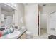 Well-lit bathroom featuring a sink, toilet, mirror, and a shower with gray and white tile at 3428 Soho # 301, Orlando, FL 32811