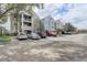 Exterior view of condo building showing the architecture and parking area on a partly cloudy day at 3428 Soho # 301, Orlando, FL 32811