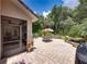 Landscaped backyard featuring a brick patio, barbecue grill, lush greenery, and mature shade trees at 3556 Sunset Isles Blvd., Kissimmee, FL 34746