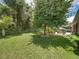 Lush backyard featuring a large lawn, mature trees, and a brick patio with outdoor furniture at 3556 Sunset Isles Blvd., Kissimmee, FL 34746