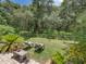 Spacious backyard features a lush lawn, mature trees, lounge chairs, and well-maintained landscaping at 3556 Sunset Isles Blvd., Kissimmee, FL 34746