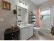 Well-lit bathroom features a white vanity and sink, complemented by a framed mirror and tub with shower at 3556 Sunset Isles Blvd., Kissimmee, FL 34746