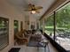 Enclosed sunroom boasts large windows offering serene views, comfortable seating, and a ceiling fan at 3556 Sunset Isles Blvd., Kissimmee, FL 34746