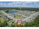 Aerial view of a modern home in a suburban neighborhood with a community pool, lake, and natural preserve at 3759 Crimson Clover Dr, Mount Dora, FL 32757