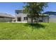 Large backyard features lush green grass, a covered patio, and serene views, perfect for relaxation and outdoor activities at 3759 Crimson Clover Dr, Mount Dora, FL 32757