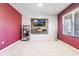 Versatile bonus room with carpeted floors, modern wall-mounted TV, and ample natural light, perfect for a home theater at 3759 Crimson Clover Dr, Mount Dora, FL 32757