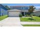 Charming two-story home with manicured lawn, a two-car garage, and beautiful landscaping at 3759 Crimson Clover Dr, Mount Dora, FL 32757