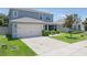 Charming two-story home with manicured lawn, a two-car garage, and beautiful landscaping at 3759 Crimson Clover Dr, Mount Dora, FL 32757