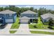 Two-story home featuring a well-manicured lawn, attached two-car garage, and modern architecture with a gray facade at 3759 Crimson Clover Dr, Mount Dora, FL 32757