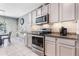Modern kitchen with gray cabinets, stainless steel appliances, and granite countertops at 3759 Crimson Clover Dr, Mount Dora, FL 32757