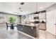 Modern kitchen with gray cabinets, stainless steel appliances, an island, and granite countertops at 3759 Crimson Clover Dr, Mount Dora, FL 32757
