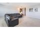 Cozy living room boasts plush carpet, a comfortable gray sectional sofa, and soothing neutral tones at 3759 Crimson Clover Dr, Mount Dora, FL 32757