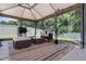 Relaxing outdoor patio area featuring comfortable seating under a shaded canopy, perfect for entertaining and enjoying the outdoors at 3759 Crimson Clover Dr, Mount Dora, FL 32757