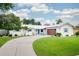 Charming single-story home with a well-manicured lawn, circular driveway, and modern exterior paint at 402 Saint Dunstan Way, Winter Park, FL 32792