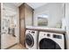 Bright laundry room with white washer and dryer, tile floors, and modern cabinetry for efficient storage solutions at 402 Saint Dunstan Way, Winter Park, FL 32792