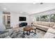 Inviting living room featuring tile flooring, a media center, and a large window for natural light at 402 Saint Dunstan Way, Winter Park, FL 32792
