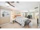 Spacious main bedroom with a large bed, natural light, a ceiling fan, and a dedicated workspace at 402 Saint Dunstan Way, Winter Park, FL 32792