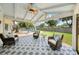 Covered patio featuring patterned tile, stylish chairs, ceiling fan, and a view of the backyard pool at 402 Saint Dunstan Way, Winter Park, FL 32792