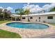 Sparkling backyard swimming pool with a brick patio, palm trees, and an updated white home exterior at 402 Saint Dunstan Way, Winter Park, FL 32792
