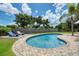 Backyard swimming pool with brick patio, wood deck, lounge chairs, and landscaped yard at 402 Saint Dunstan Way, Winter Park, FL 32792
