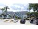 Clubhouse featuring a well-manicured front lawn, car parking, and stylish architectural details at 4606 Commander Dr # 1126, Orlando, FL 32822
