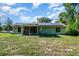 Exterior view of backyard featuring solar panels, screen porch and spacious lawn at 468 E Oakwood Ave, Orange City, FL 32763