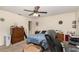 Bedroom with ceiling fan and a large dresser; a pet bed sits adjacent to a bed covered with a blue patterned comforter at 468 E Oakwood Ave, Orange City, FL 32763