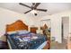 Bedroom with a ceiling fan, wood-framed bed, dresser, and closet with mirrored sliding doors at 468 E Oakwood Ave, Orange City, FL 32763