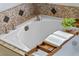 A stylish soaking tub is adorned with decorative tile and a bamboo bath caddy at 5102 Round Tree Ct, Orlando, FL 32819