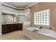 Luxurious bathroom with soaking tub, tile surround, and double vanities at 5102 Round Tree Ct, Orlando, FL 32819