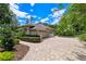 Side angle view of this well-maintained home featuring beautiful landscaping and a paved driveway at 5102 Round Tree Ct, Orlando, FL 32819