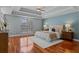 Spacious main bedroom with hardwood floors, tray ceiling, and large arched window at 5102 Round Tree Ct, Orlando, FL 32819