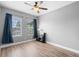Well-lit bedroom with wood-look floors, neutral walls, a ceiling fan, and ample natural light from two windows at 528 Lanark Ct, Orlando, FL 32806