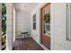 Charming front porch with a bistro set and a decorative wreath on the door at 528 Lanark Ct, Orlando, FL 32806