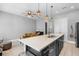 Bright, open kitchen features a large island with bar seating, stainless steel sink, and modern pendant lighting at 528 Lanark Ct, Orlando, FL 32806