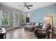 Bright living room with a cozy gray sectional, recliner, ceiling fan, and natural light from the windows at 528 Lanark Ct, Orlando, FL 32806