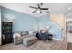 Comfortable living room with a gray sofa, recliner, modern ceiling fan, and staircase to the upper level at 528 Lanark Ct, Orlando, FL 32806