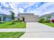 Two-story home with beige exterior, green lawn, and a two car garage at 5345 Tuscany Ln, Davenport, FL 33897