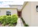 Front entrance of the house with a red door, green bushes, and concrete walkway at 5345 Tuscany Ln, Davenport, FL 33897