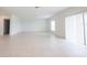 Large, open living room with light tile flooring and a sliding glass door for ample natural light at 5345 Tuscany Ln, Davenport, FL 33897