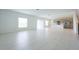 Sunlit living room featuring light tile flooring, a kitchen, and a stairway in an open layout at 5345 Tuscany Ln, Davenport, FL 33897