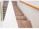 Carpeted staircase with wooden handrail and white banister, leading to the upper level of the home at 5345 Tuscany Ln, Davenport, FL 33897