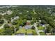 An aerial view shows the home nestled in a lush, green, tree-filled neighborhood at 608 Cedar Ave, Holly Hill, FL 32117