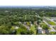 A neighborhood view shows a home surrounded by mature trees near a city skyline and waterways at 608 Cedar Ave, Holly Hill, FL 32117