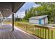 Wooden deck overlooking a spacious backyard and detached garage painted with coordinating blue doors at 608 Cedar Ave, Holly Hill, FL 32117